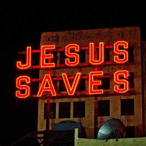 a large neon sign that says jesus saves on the side of a building at night