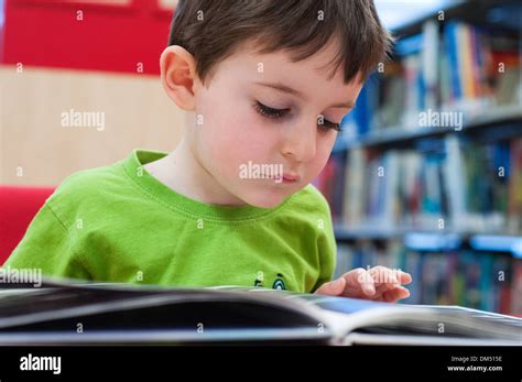 Child reading at public library Stock Photo - Alamy