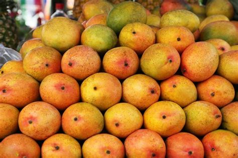 Premium Photo | Pile of delicious ripe yellow mangoes closeup