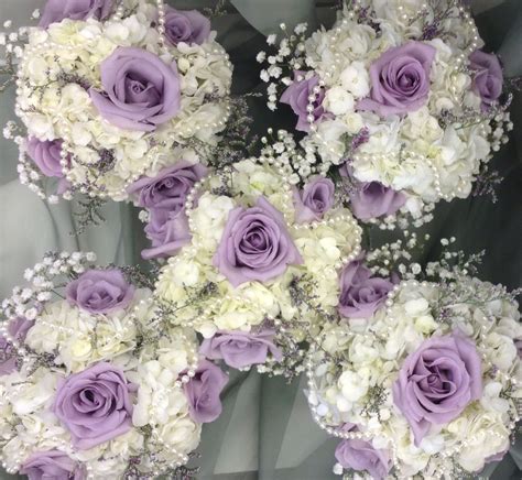 Lavender and white bridesmaids bouquets with hydrangea, roses, babies breath and pearl accents ...