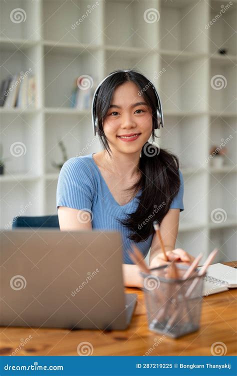 A Female College Student Smiling at the Camera, Wearing Headphones ...
