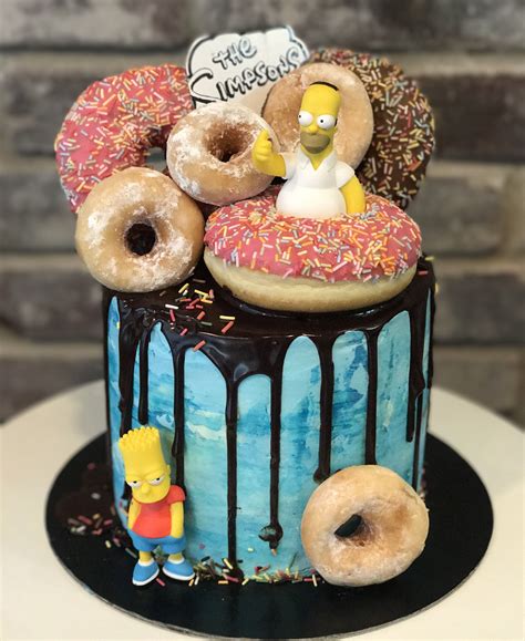 a cake decorated with donuts, sprinkles and simpsons characters on top