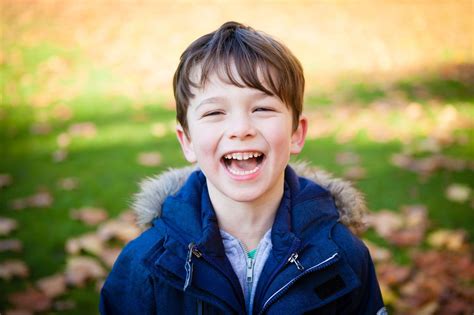 Young boy laughing outside, in park during Beckenham family photoshoot ...