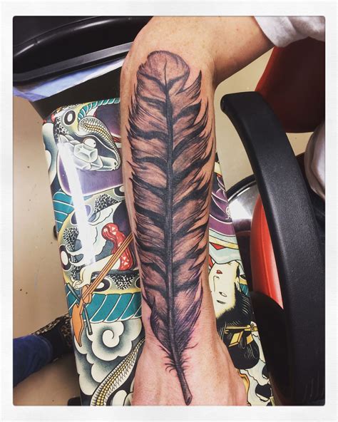 Super cool owl feather tattoo done in black and grey.