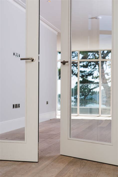 Contemporary white washed Ash veneer Trinity style double doors with large vision panels by ...