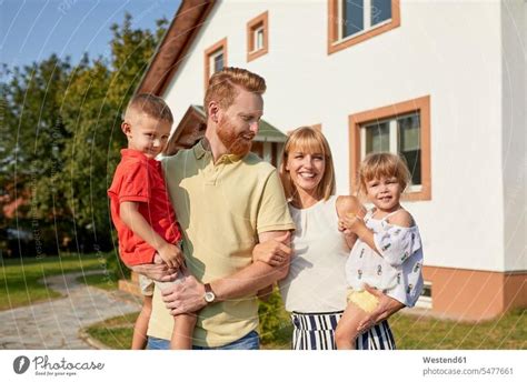 Portrait of happy family in garden of their home - a Royalty Free Stock Photo from Photocase