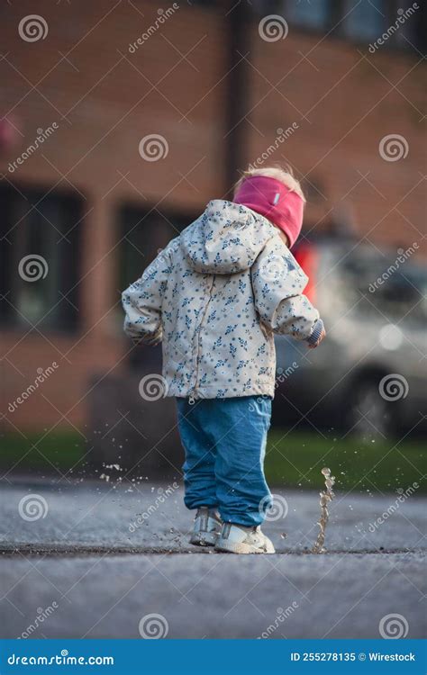 Kid Playfully Jumping into the Puddle Stock Image - Image of feet, playing: 255278135