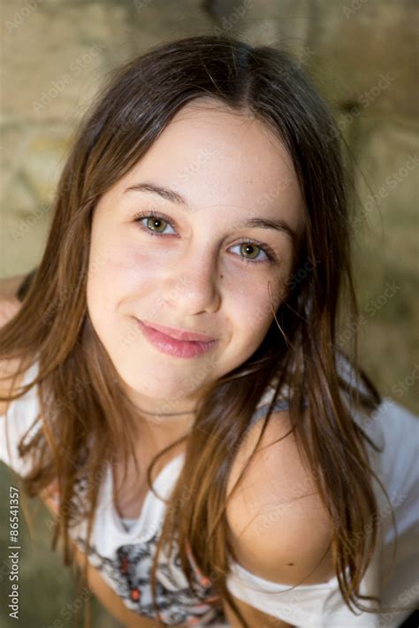 A cute teenage girl of 12 years old smiling at the camera Stock Photo | Adobe Stock