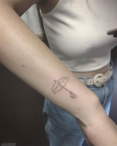 Small umbrella tattoo on the wrist - Tattoogrid.net