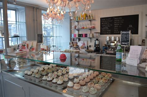 a bakery with lots of cupcakes on display in front of the counter and ...