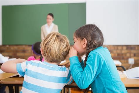 Premium Photo | Pupils whispering secrets during class