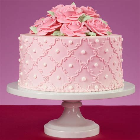 An intricate s-scroll border intertwines this delicate pink cake with ...