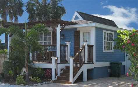 a small blue and white house with palm trees