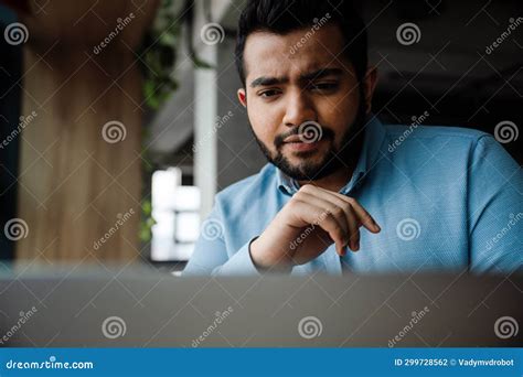 Pensive Indian Business Man Looking at Laptop Screen while Sitting in ...