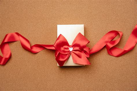 Gift box decorated with red ribbon · Free Stock Photo