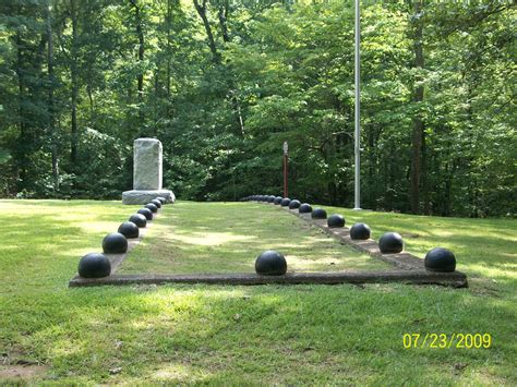 a long row of balls sitting on top of a grass covered field next to a ...