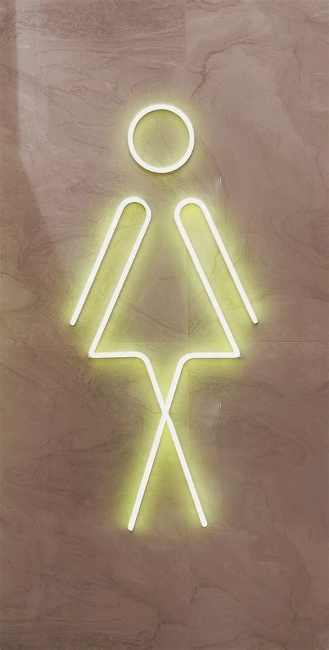 a neon sign that is on the side of a wall with a person in it