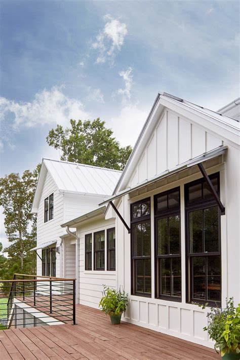 White vertical exterior siding + black trim windows + window awnings ...