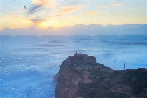 Nazare lighthouse sunset ocean Portu | Architecture Stock Photos ~ Creative Market