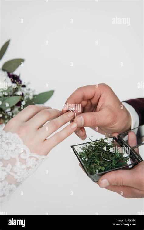 partial view of groom wearing wedding ring on bridal finger Stock Photo - Alamy