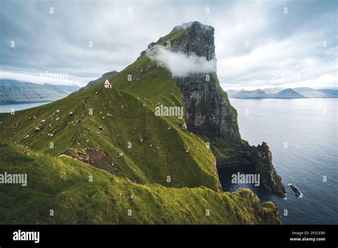 Kalsoy Island with Kallur lighthouse on on Faroe islands, Denmark, Europe. Clouds over high ...