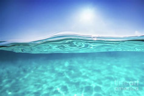 Half underwater shot, clear water and sunny blue sky. Tropical ocean Photograph by Michal ...