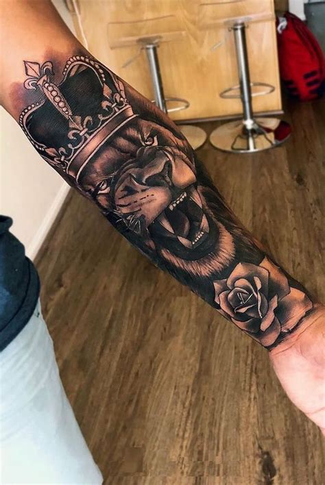 a man's arm with a lion and crown tattoo on the left side of his arm