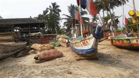 there are many boats on the beach with flags flying in the wind and one ...