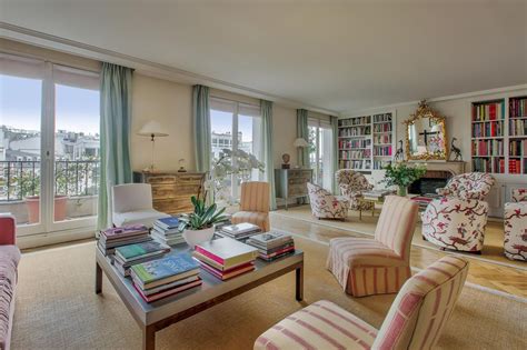 a living room filled with lots of furniture and bookshelves next to a window