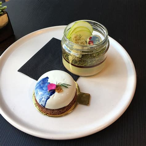 a small dessert on a white plate next to a jar of pickles and a knife