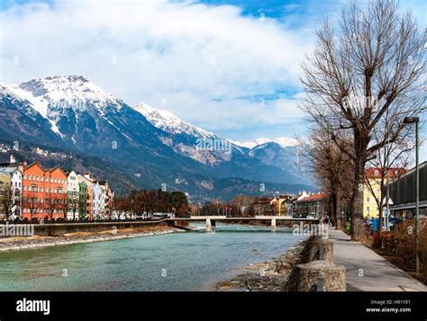 Innsbruck, Tirol, Austria. Inn river, bridge, historic houses ,Alps covered with snow and tress ...