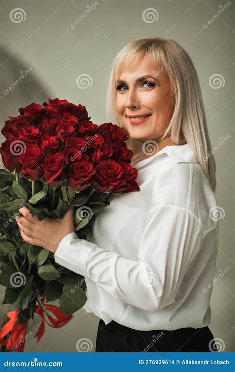 A Fashionable Woman in a White Shirt and Black Trousers Poses in the ...