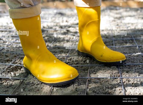 Construction worker in yellow rubber boots at the construction site ...