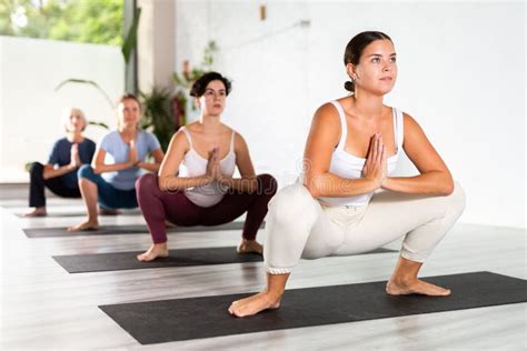 Calm European Young Woman Standing Squat Pose Malasana during Yoga Practice in Fitness Class ...