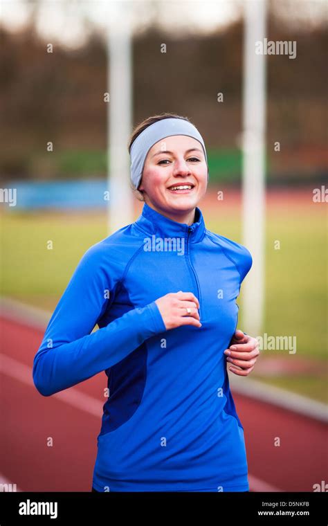 Young woman running at a track and field stadium Stock Photo - Alamy