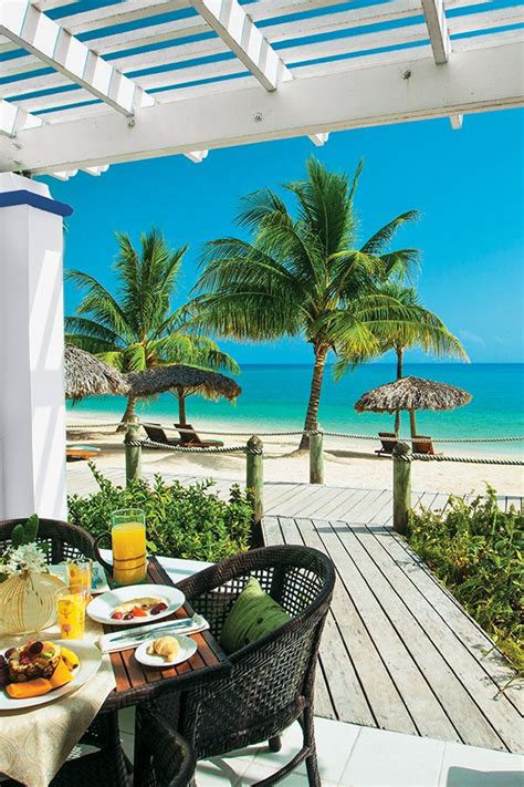 an outdoor dining area overlooking the beach and ocean