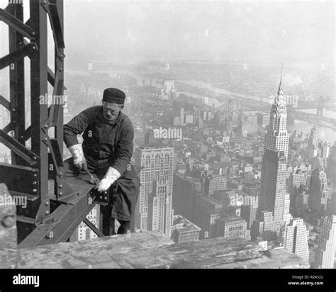 Construction worker on the Empire state building, New York City. The Chrysler building is seen ...