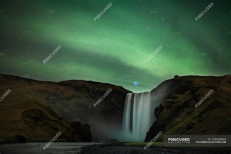 Northern Lights over Skogafoss waterfall, Iceland — vacation, ethereal ...