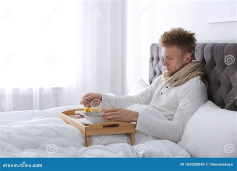 Sick Young Man Eating Soup To Cure Flu in Bed Stock Photo - Image of medication, care: 163000840