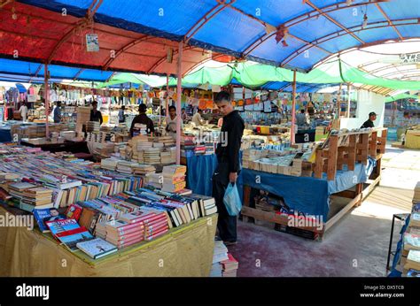 Man browses books at open air book stall in Sunday Bazaar Karachi Pakistan Stock Photo - Alamy