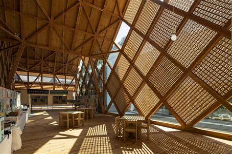 Tezuka Architects' zig zag office building creates lace-like façade with wooden diagonal grids