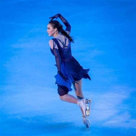 a female figure skating in a blue dress