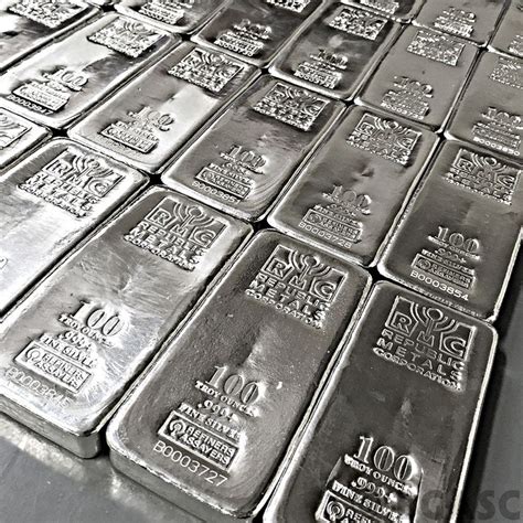 many silver bars are stacked on top of each other in this black and white photo