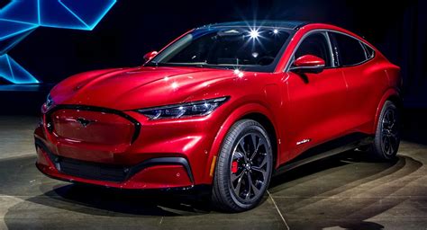 a red car is on display at an auto show in front of a blue background