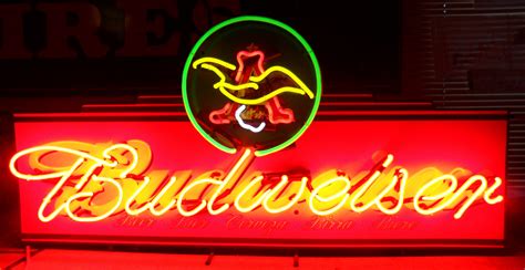 the budweiser neon sign is lit up in red, yellow and green colors