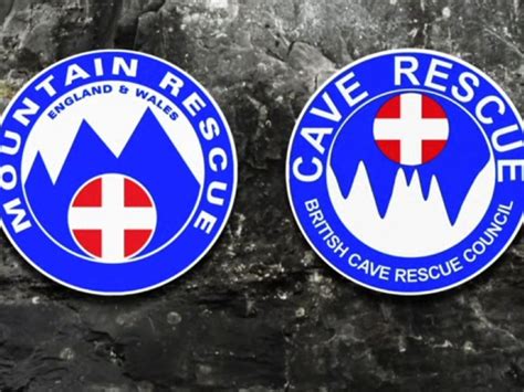 two blue and white circular badges on a rock wall with the words mountain rescue in red, white ...