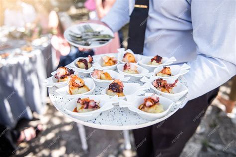 Premium Photo | Waiter carrying a white tray full of food at an event to people