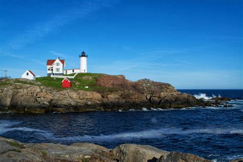 a lighthouse on top of a rocky cliff near the ocean