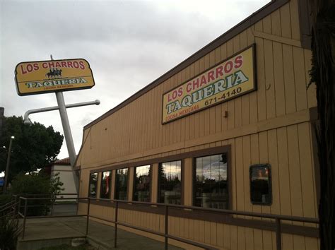 a restaurant called los charros taqueria on the corner of a street