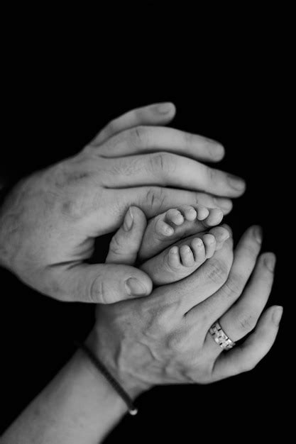 Premium Photo | Baby feet in parent's hands. newborn photography idea. family photo idea. black ...